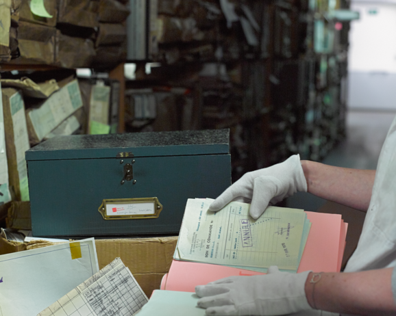 foto van iemand die door archieven bladert in het archief
